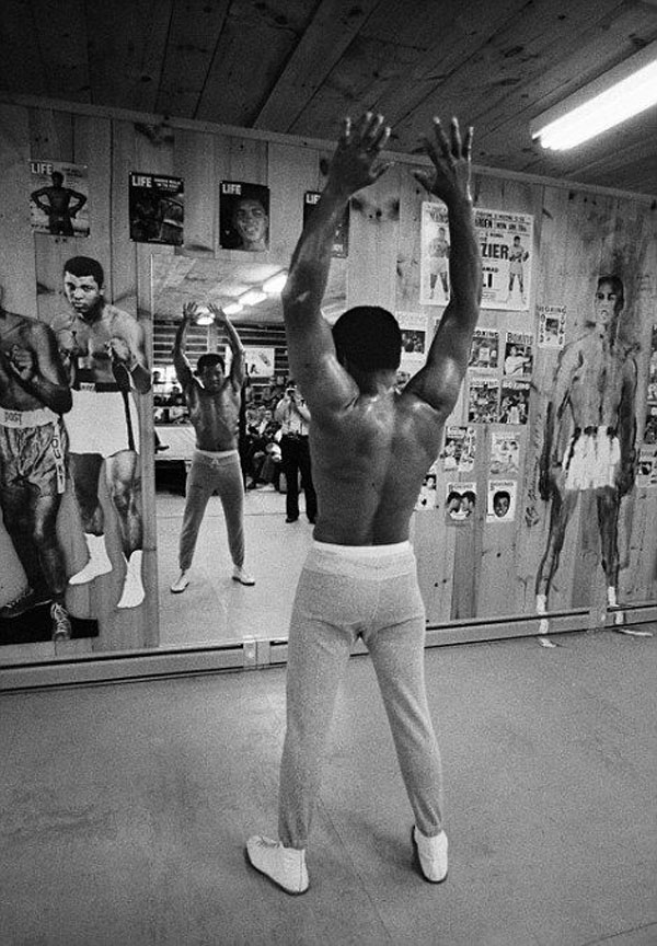 A vintage photograph capturing Muhammad Ali training in a boxing ring.