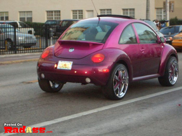 A purple volkswagen beetle is driving down the street and wondering if people will notice its arrival.