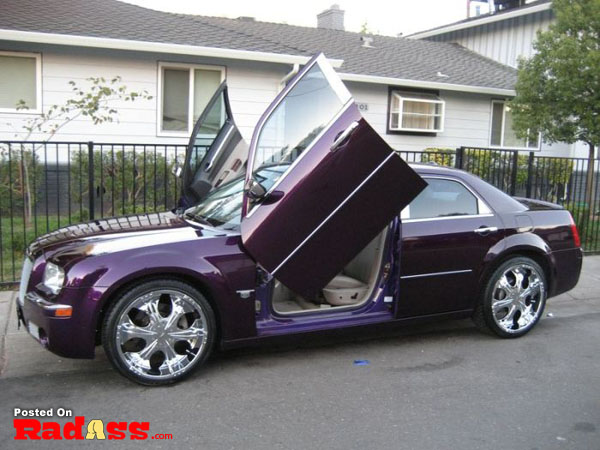 A purple chrysler 300 with open doors approaches, making a bold entrance.