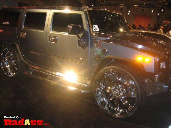 A silver hummer parked at a sparkly show.