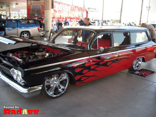 A fiery car painted in vibrant red and black hues, guaranteed to turn heads when it roars down the street.