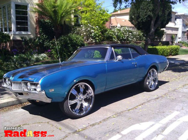 A muscle car is parked on the street, silently wondering if it will be noticed upon arrival.