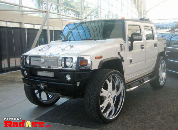 A parked white hummer in a parking lot, incognito.