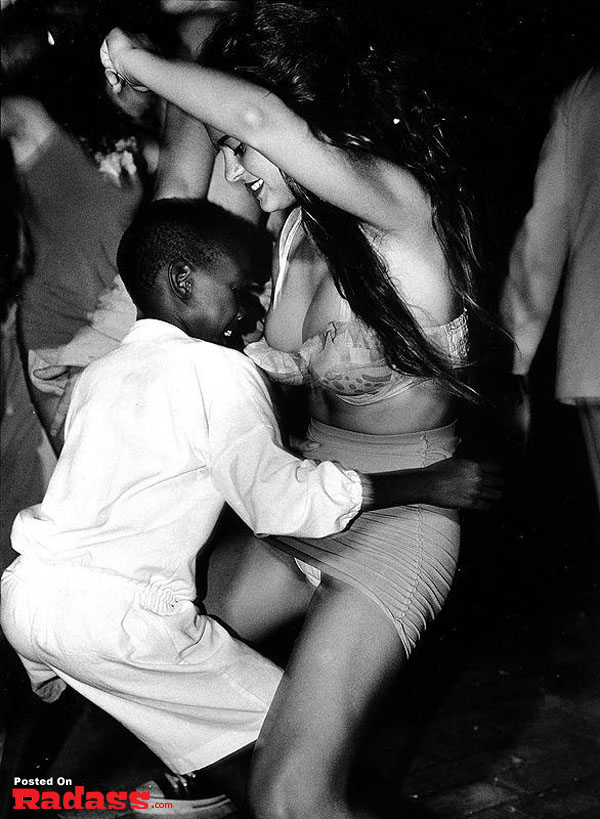 A woman dancing with a young boy at a party.
