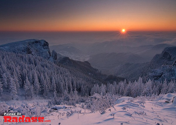 The sun is setting over a snow covered mountain, providing a breathtaking view to escape the everyday stresses.