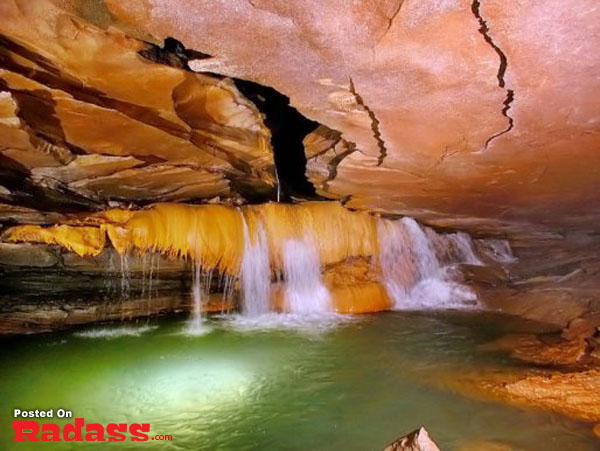 A captivating cave oasis boasting a mesmerizing waterfall.