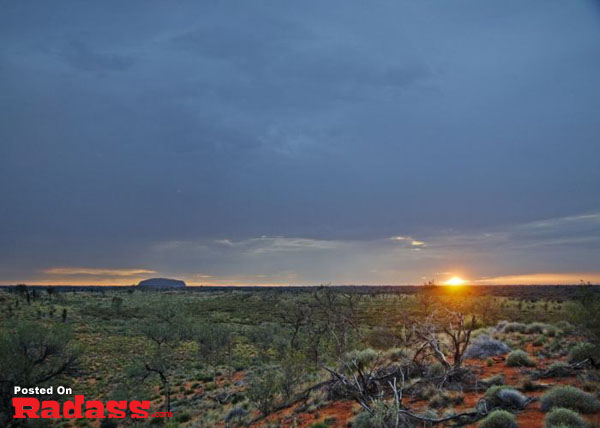 The sun is setting over Uluru in the Australian outback, offering a captivating scene for those craving an escape or a moment of tranquility.