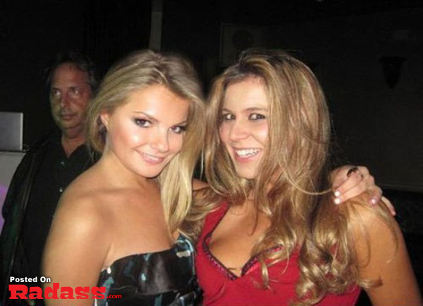 Two women posing for a celebrity-style picture at a party.