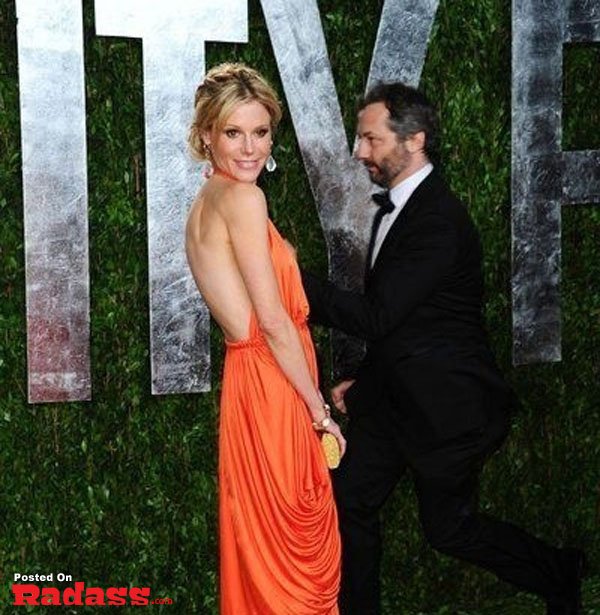 A man and a woman in an orange dress, photobombing celebrity style.