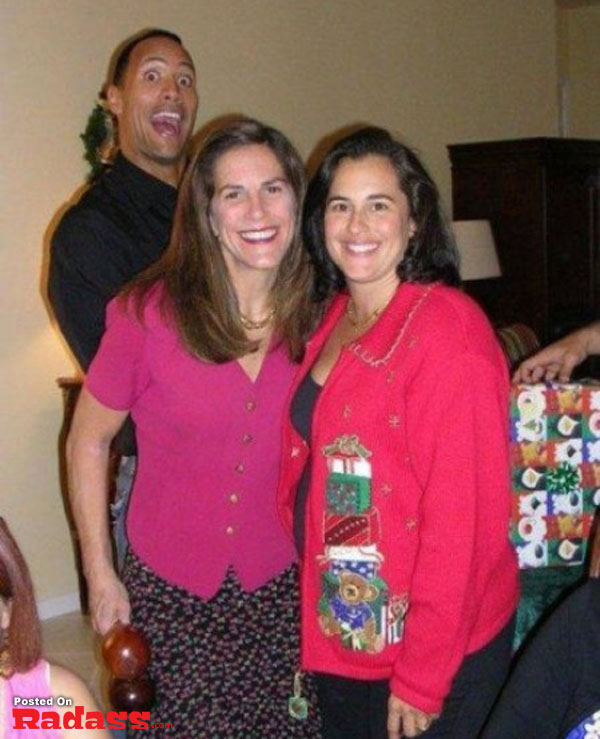 A group of people posing for a picture at a Christmas party with celebrity-style photobombs.