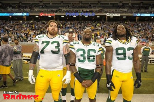 Green Bay Packers players stand on the field during the national anthem, celebrity style.