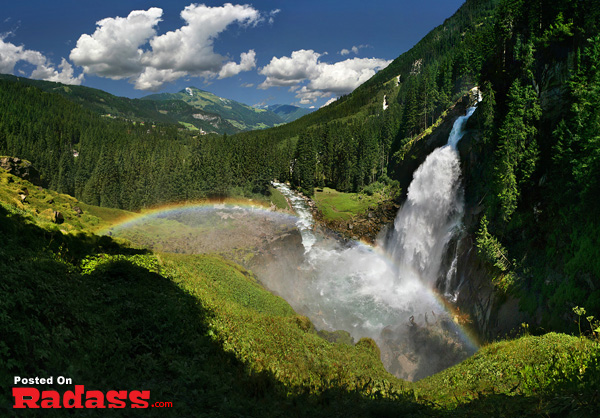 An ethereal rainbow contrasting a majestic mountain waterfall offers an escape from civilization.