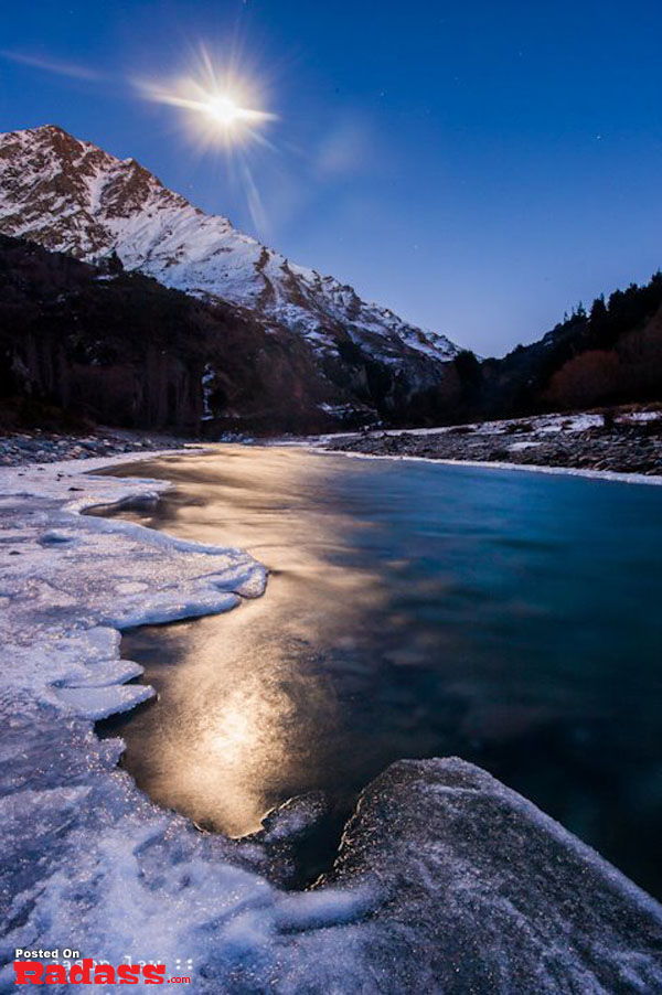 A full moon rises over a frozen river, offering an escape from civilization.