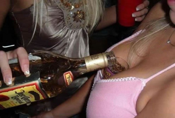 A woman holds a bottle of liquor, ensuring you'll need a drink after viewing these 34 photos.