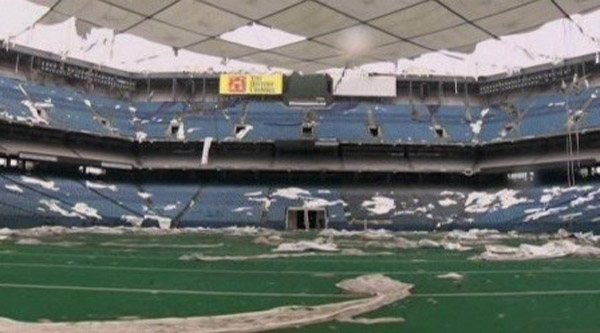 Abandoned football stadium covered in debris.