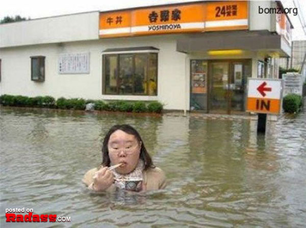 A woman WTF Japan stands in a flooded area in front of a store, documented through 46 pics.
