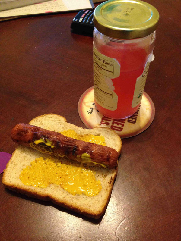 A hot dog on a slice of bread next to a jar of jelly, a must-have among the 16 essential meals for college students.