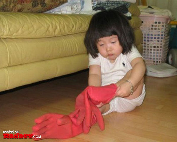 A little girl playing with a red glove on the floor in WTF Japan.