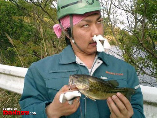 A bizarre image captured in Japan featuring a man wearing a mask while displaying a fish, leaving viewers perplexed.