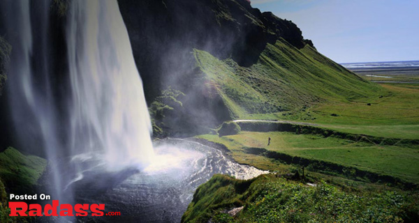A picturesque waterfall situated in an idyllic grassy field.