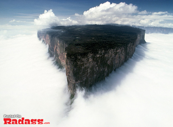 A mountain cliff piercing through the clouds.