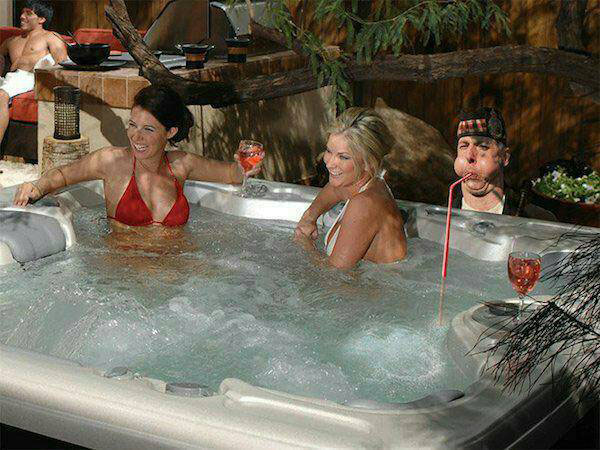 Two women in bikinis having a relaxing time in a hot tub, while Bagpipe Guy Gets Extreme Photoshop Makeover (17 Photos)