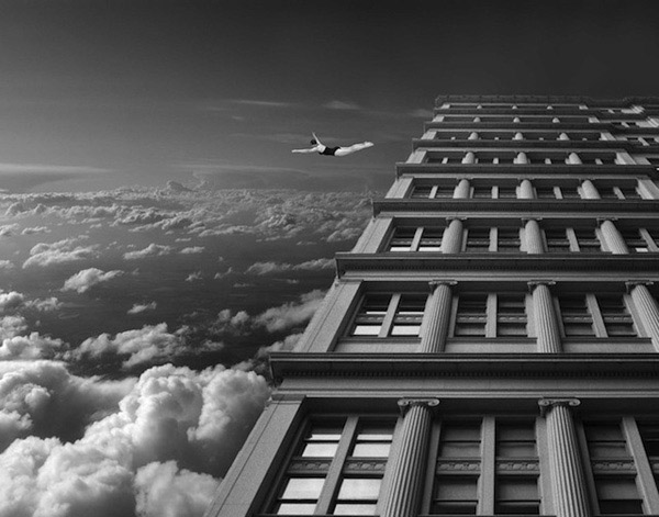 A captivating black and white photo of an airplane soaring over a building. (Thomas Barbéy, 22 Photos)