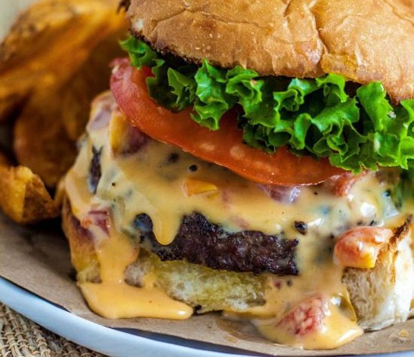 An awesome burger with cheese and tomatoes served on a plate, perfect for 2022.