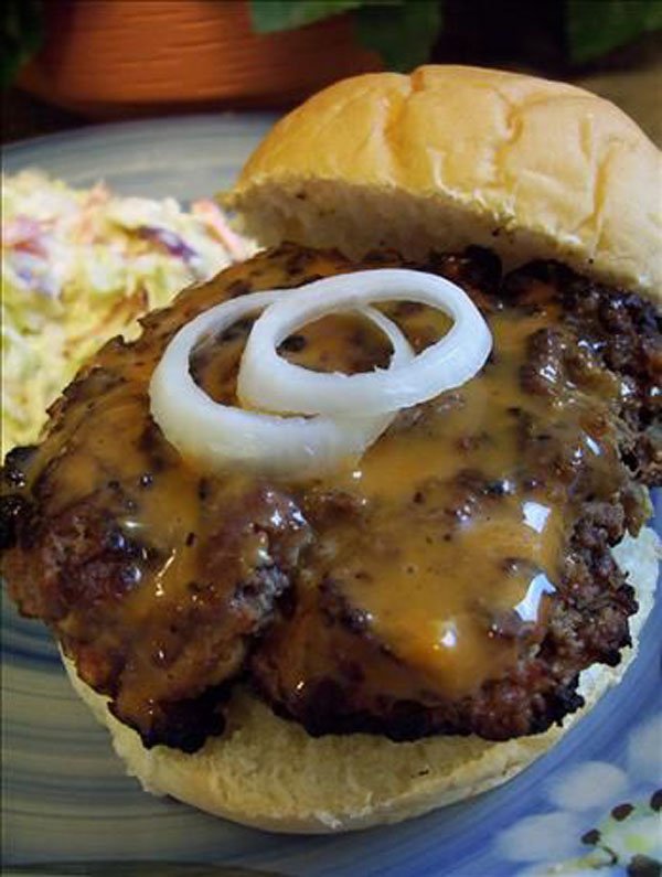 An awesome burger topped with onions and ketchup on a plate, perfect for 2022.