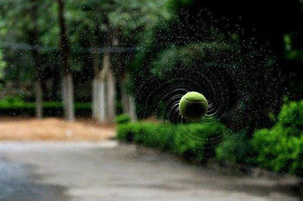 A cool pic of a green ball soaring through the air.
