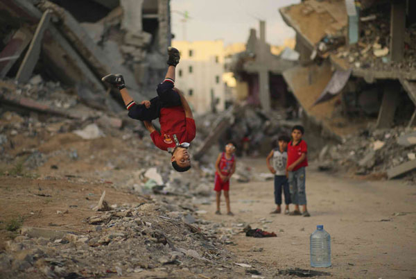 A boy does a handstand in the cool rubble of a city, brightening your day.