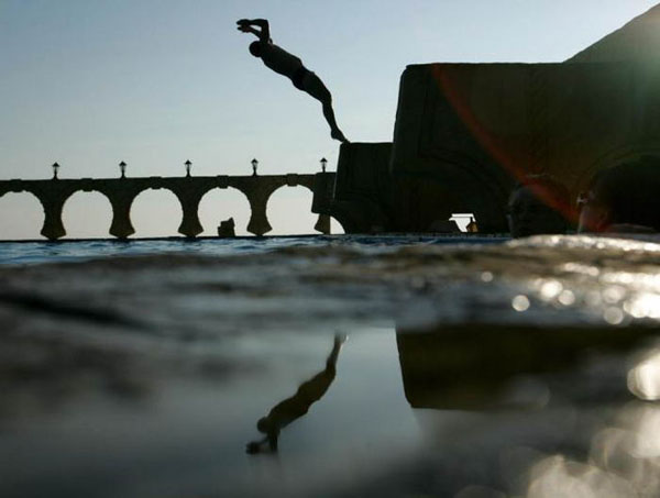 A man takes a refreshing plunge into the water, captured in one of these cool pics to brighten your day.