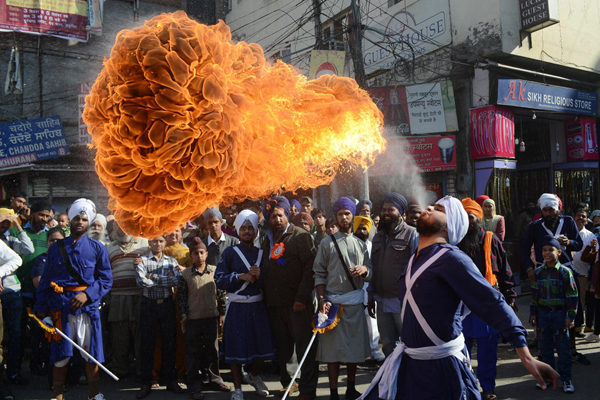 A man in a turban performs a fire dance in front of a crowd, providing plenty of cool pics to brighten your Saturday.