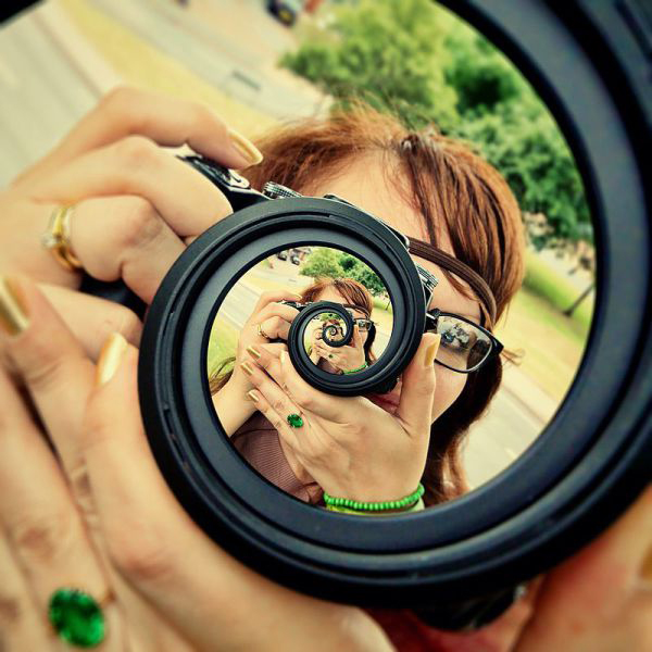 A woman capturing plenty of cool pics with her camera, sure to brighten your Saturday.