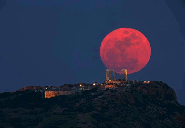 40 Cool Pics Just To Make Your Day: A red moon rises over a hill.