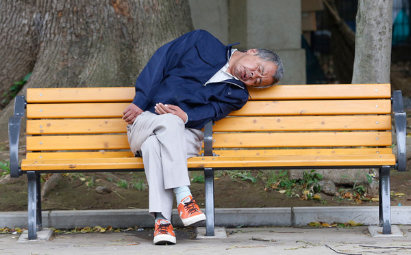 A man enjoying a peaceful nap on a park bench, captured in plenty of cool pics to brighten your Saturday.