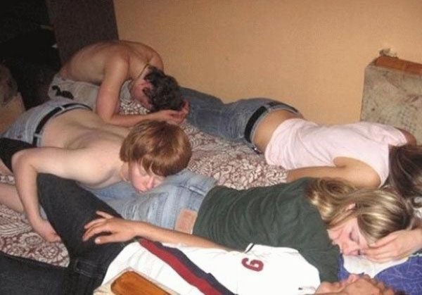 A group of friends drinking excessively on a bed.