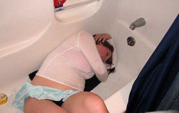 A woman passed out in a bathtub after drinking excessively.