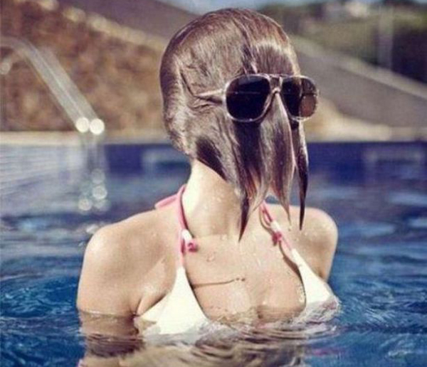 A woman wearing sunglasses and a hat in a swimming pool, making for an irresistible allure.