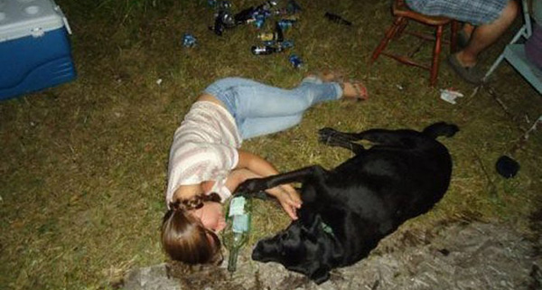 A woman laying on the ground next to a black dog, but there's a twist in the story...