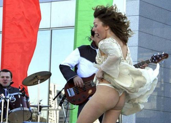 A woman in a white bikini dancing in front of a band.