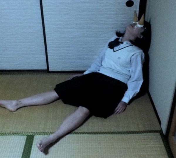 A girl laying on the floor in a room, pondering 