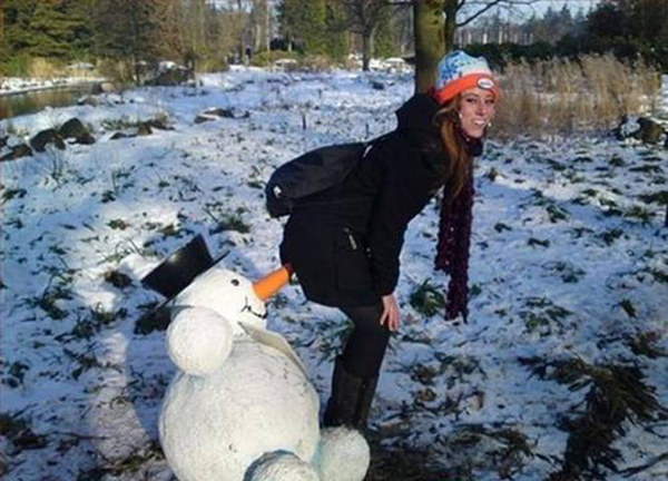 A woman posing next to a snowman in the snow, looking affectionately 

Keywords Used: Snowman, Snow