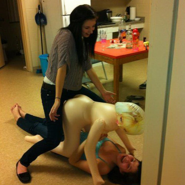 Two women playfully interact with a mannequin, expressing a lighthearted 