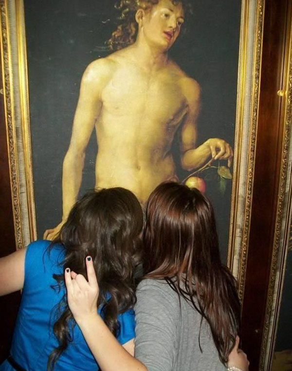 Two women hugging in front of a painting of jesus.
