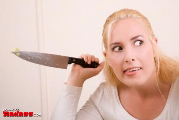 A woman is playfully holding a knife in front of her face, adding an element of danger to the phrase 