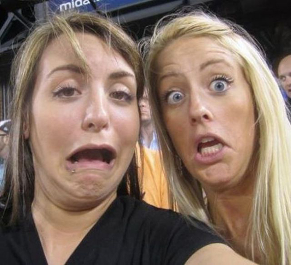 Two women taking a selfie at a baseball game, capturing happy memories together.