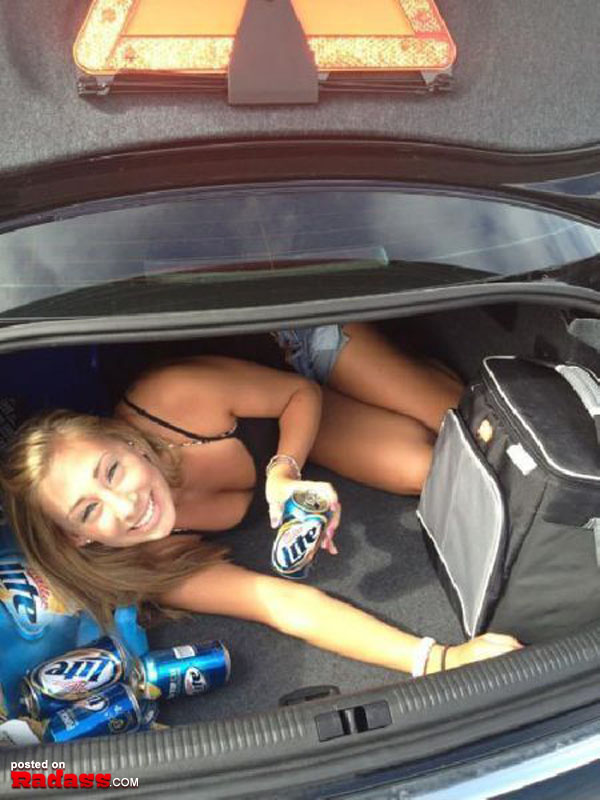 A girl sitting in the trunk of a car, contemplating 
