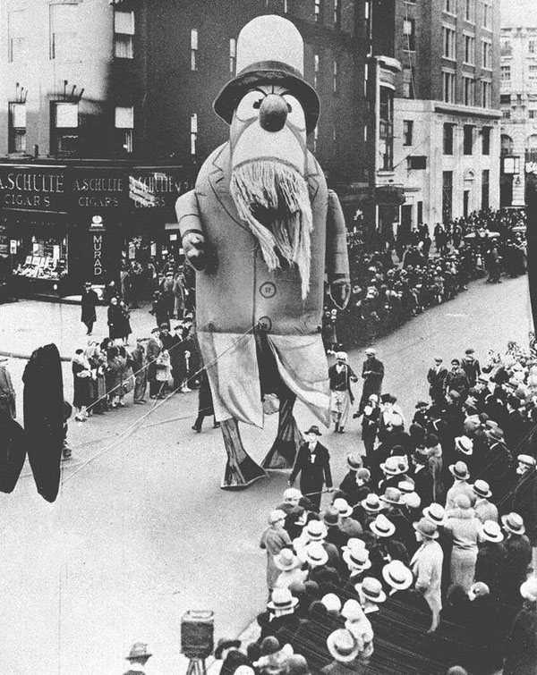 An old photo of a float with a man in a hat, captured during the Macy's Day Parade.