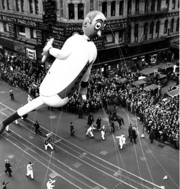 A creepy old photo of a balloon flying over a city during the Macy's Day Parade.